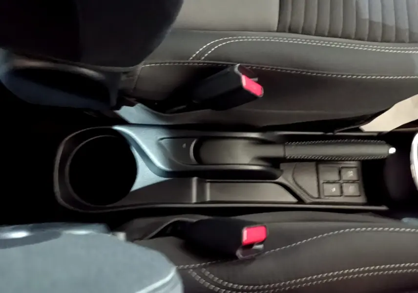 Vue plongeante sur la console centrale noire de la Toyota Yaris hybride 2019, avec frein à main et boutons de commande.