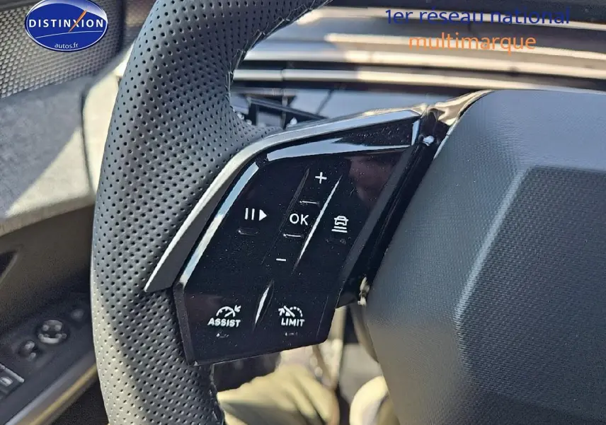 Gros plan sur les commandes multifonctions du volant cuir perforé du Peugeot 3008 noir perla nera, côté gauche.