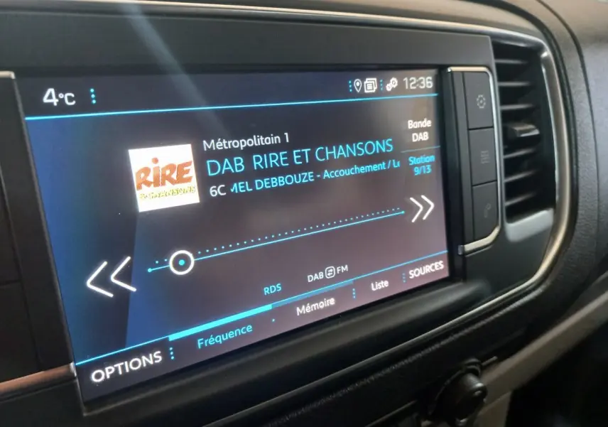 Écran tactile multimédia du tableau de bord du Peugeot Traveller gris clair, affichant une station radio DAB.