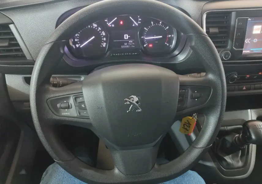 Vue rapprochée du volant noir et du tableau de bord digital du Peugeot Traveller 2021 avec levier de vitesses manuel.