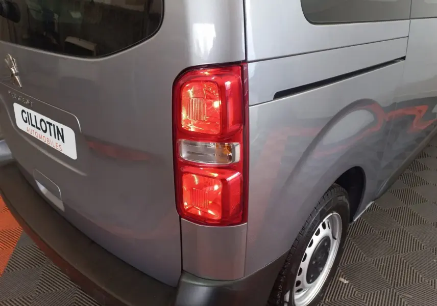 Vue arrière droite du Peugeot Traveller gris clair 2021, mettant en valeur le feu arrière et la roue acier.