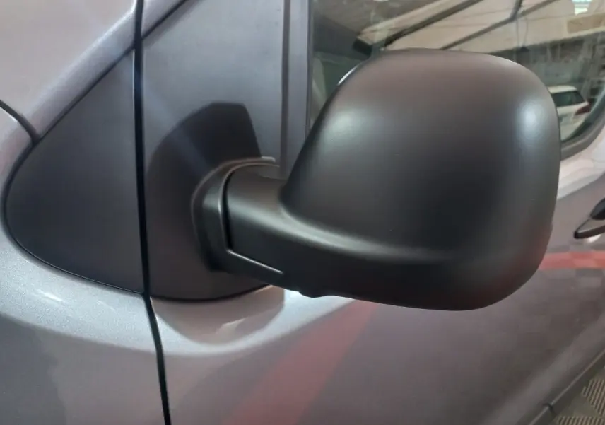 Rétroviseur noir côté droit du Peugeot Traveller gris clair, vue rapprochée sur la portière avant.