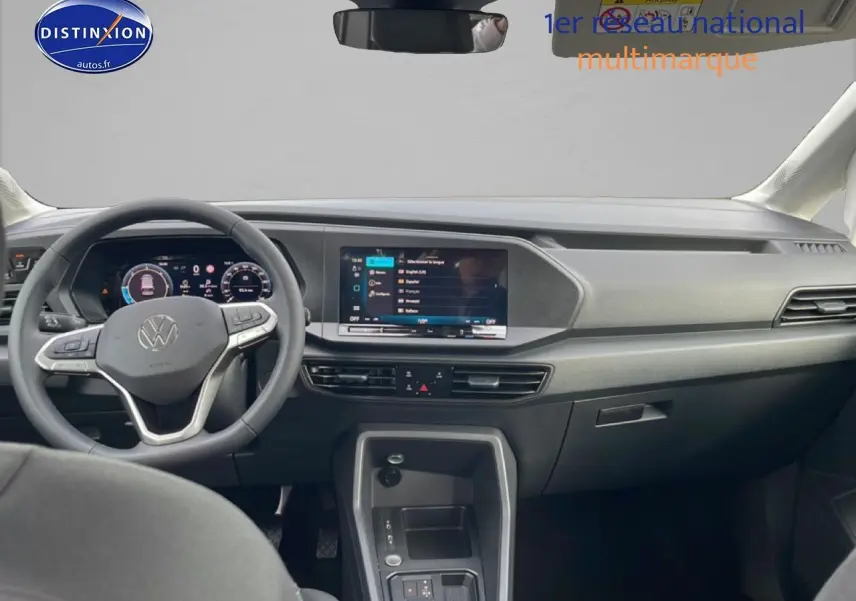 Vue intérieure avant du Volkswagen Caddy gris indien 2025, volant cuir multifonction et écran tactile 10 pouces.