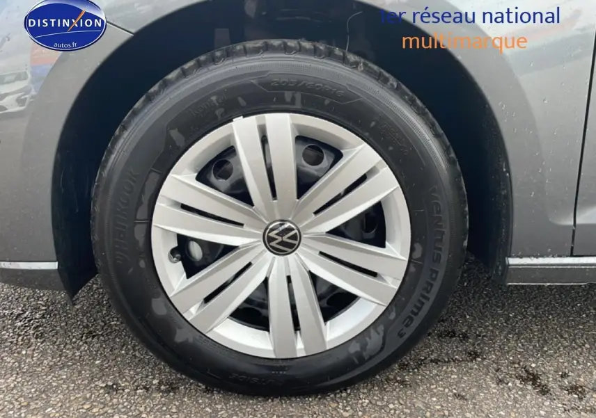 Gros plan sur la roue avant droite grise d'un Volkswagen Caddy 2.0 TDI 122 DSG7 avec jante argentée.