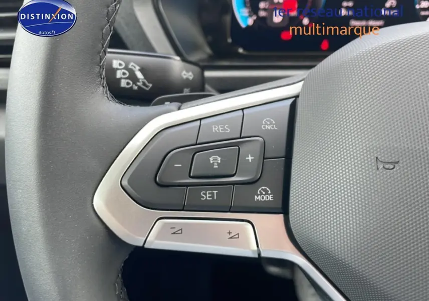 Gros plan sur les commandes multifonctions du volant cuir du Volkswagen Caddy gris indien, côté gauche.