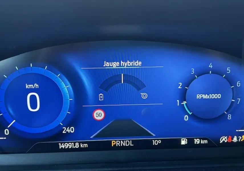 Combiné d'instrumentation numérique bleu de la Ford Puma 2023 avec jauge hybride et affichage vitesse à 0 km/h.