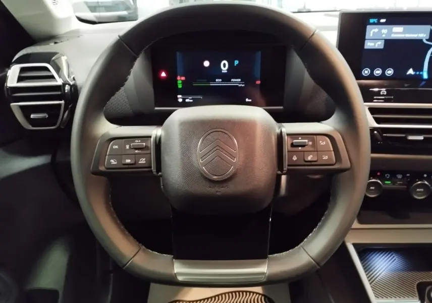 Vue frontale du volant cuir noir de la Citroën C4 2025 avec tableau de bord numérique et écran tactile central.