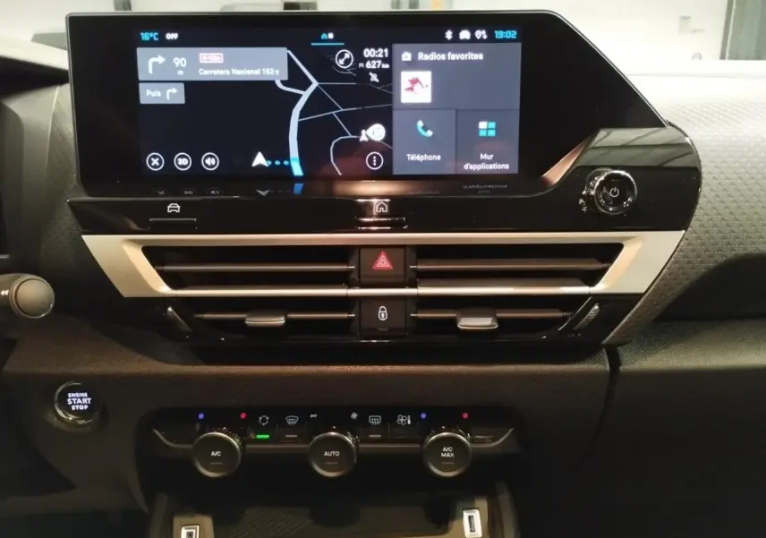 Vue rapprochée du tableau de bord de la Citroën C4 2025, écran tactile central et commandes climatisation visibles.