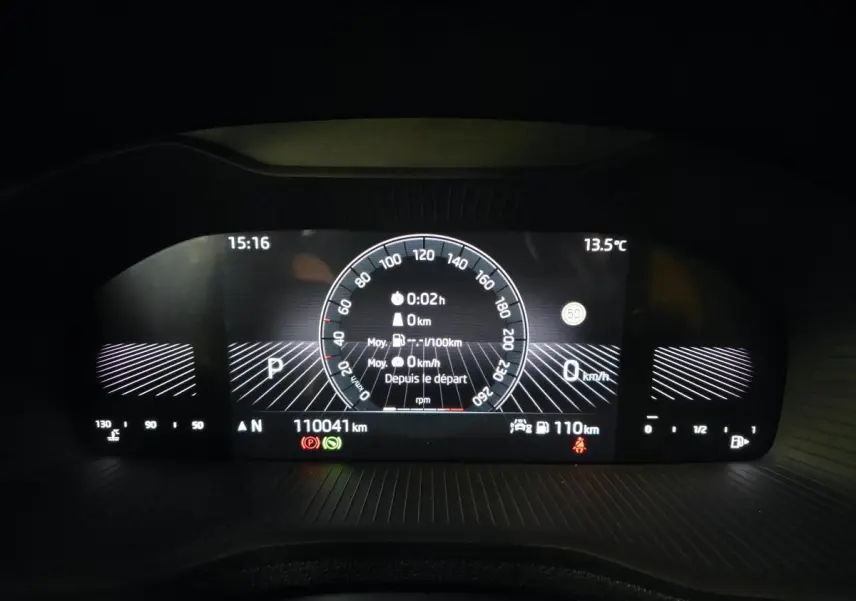 Tableau de bord numérique du Skoda Karoq blanc 2023, affichage vitesse, température et autonomie.