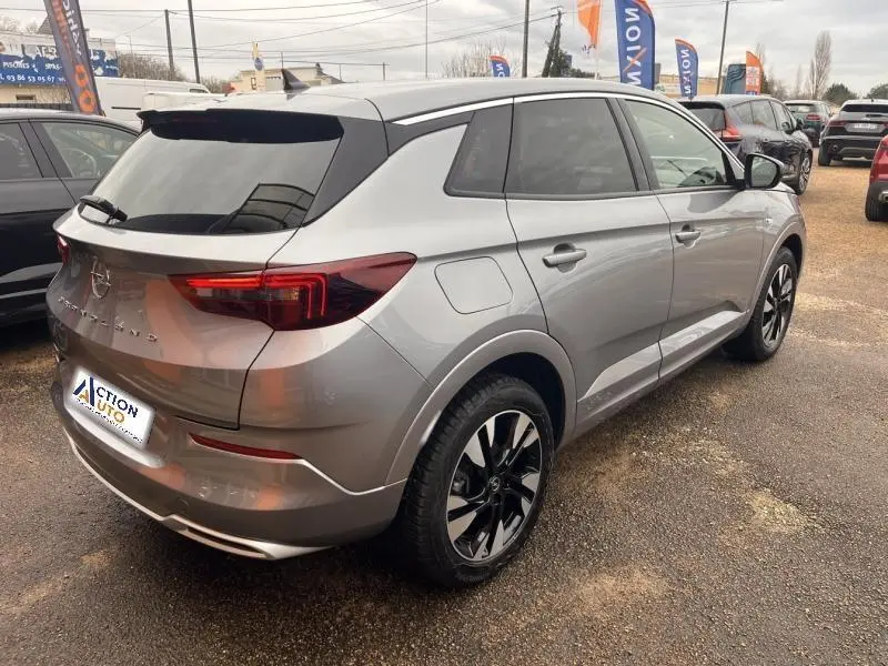 Vue 3/4 arrière droite d'un Opel Grandland gris Kontrast métallisé avec jantes alu noires et vitres surteintées.