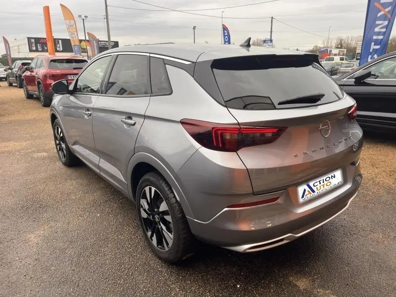 Vue 3/4 arrière droite d'un Opel Grandland gris Kontrast métallisé avec vitres surteintées et jantes alu noires.