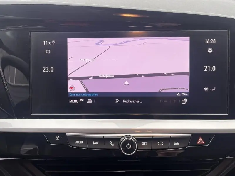Vue rapprochée de l'écran tactile central du tableau de bord de l'Opel Grandland gris, affichant la navigation GPS.
