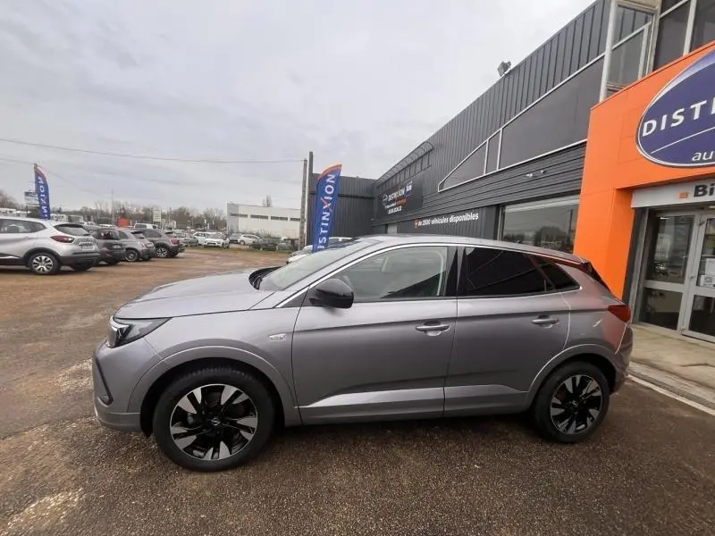 Opel Grandland gris Kontrast métallisé vu de profil côté gauche, avec jantes alliage noires et vitres arrière surteintées.