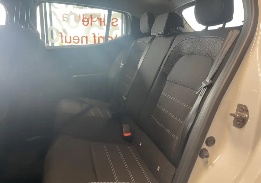 Vue intérieure côté droit de la banquette arrière noire avec ceintures de sécurité d'une Dacia Sandero blanche 2024.