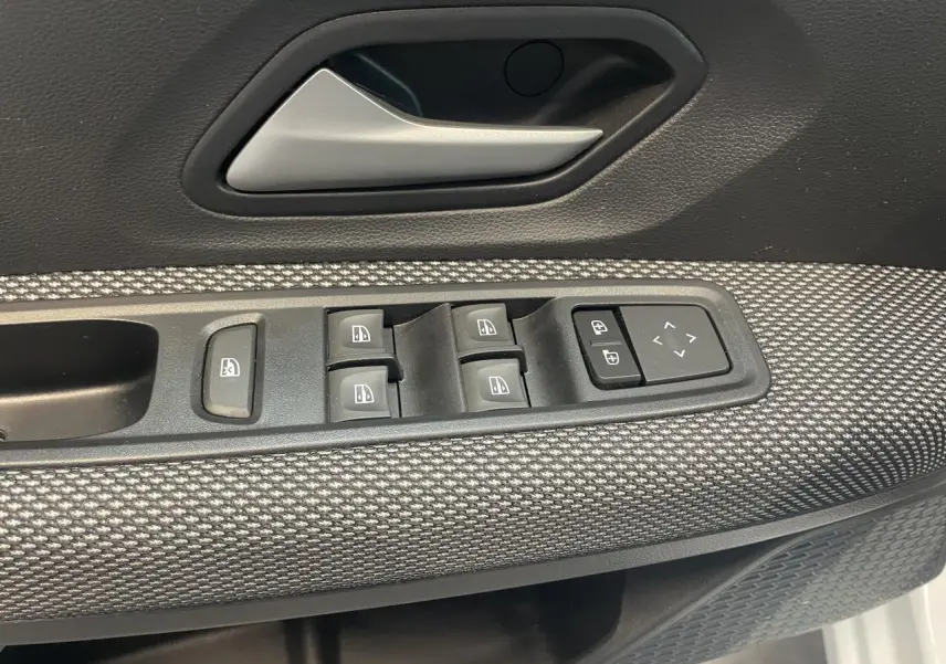 Détail de la porte avant gauche de la Dacia Sandero 2024, avec commandes de vitres et poignée argentée.