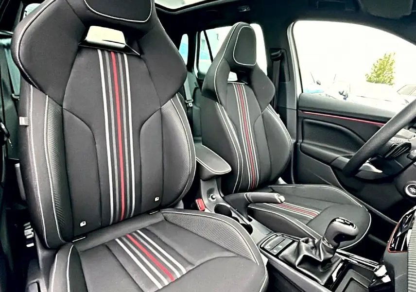 Intérieur SKODA KAMIQ Monte Carlo 2026, vue côté droit sur sièges sport noirs avec bandes rouges et grises.