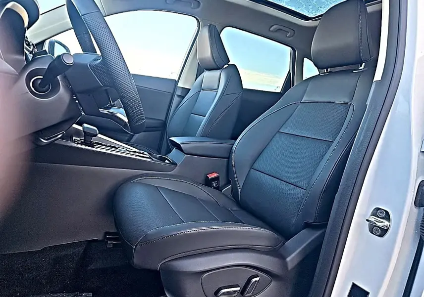 Intérieur du MG ZS 1.5 hybrid 197 luxury blanc, vue côté conducteur avec sièges en similicuir noir et toit panoramique.