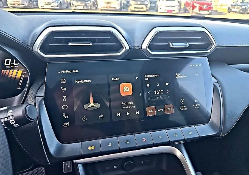 Vue rapprochée du tableau de bord noir du MG ZS 1.5 hybrid 197 luxury avec écran tactile multifonction allumé.