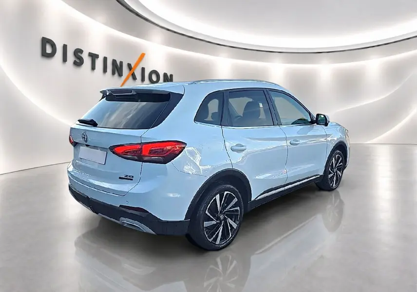 Vue 3/4 arrière droite du MG ZS blanc 2026 avec jantes alliage noires et toit panoramique en verre.