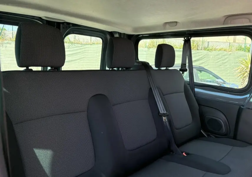 Banquette arrière trois places en tissu noir vue côté droit dans le Renault Trafic Fourgon Urban Grey 2024.