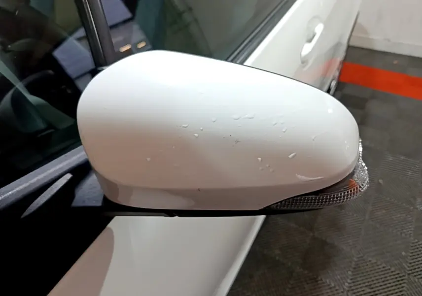 Rétroviseur droit blanc avec clignotant intégré sur Toyota Yaris hybride 2019 vue rapprochée côté conducteur.