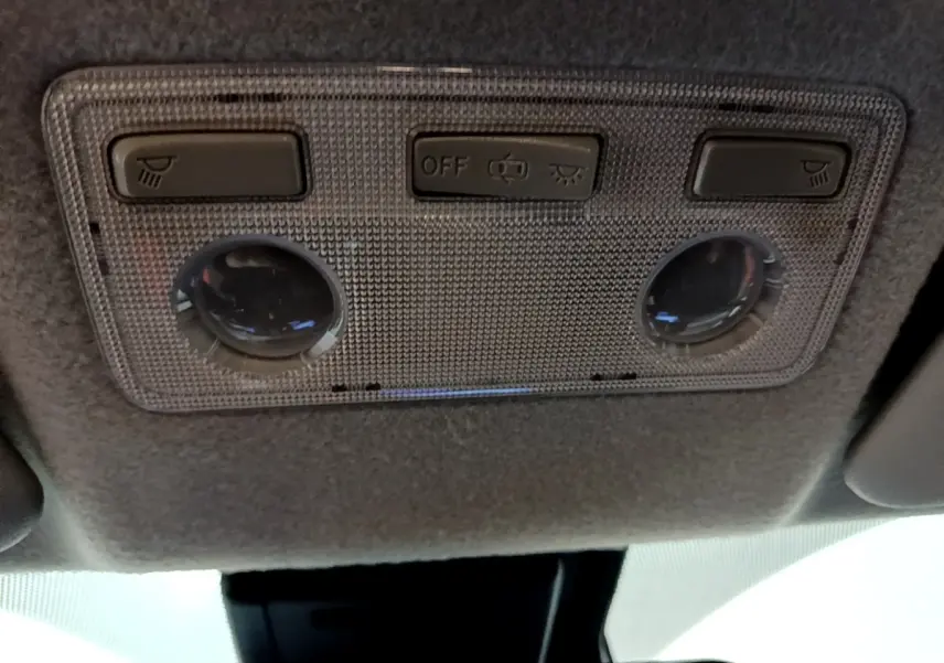 Plafonnier intérieur avec commandes d'éclairage et liseuses dans une Toyota Yaris blanche 2019, vue de dessous.