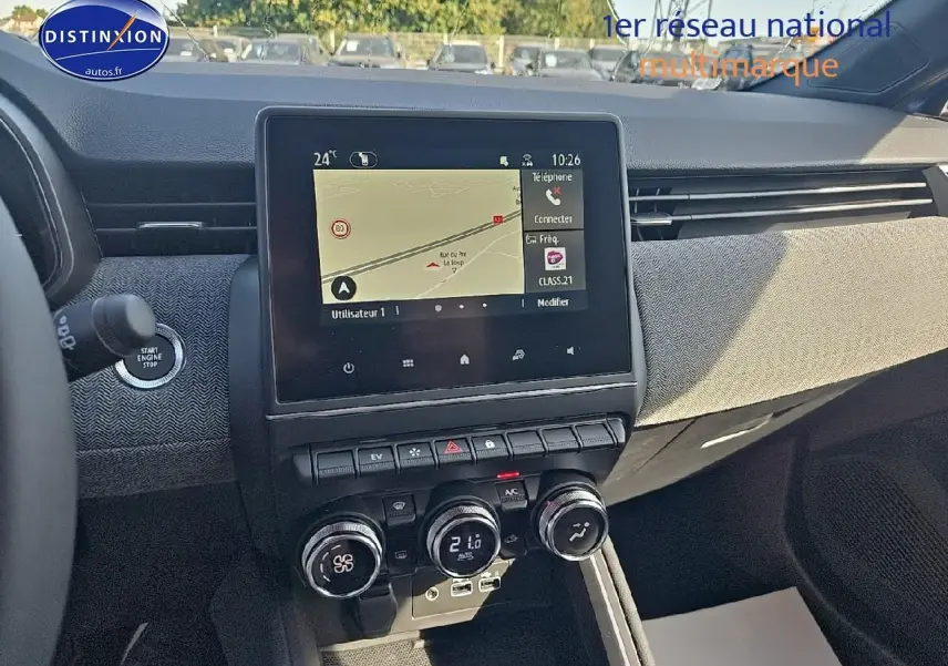 Vue intérieure du tableau de bord de la Renault Clio V 1.6 e-tech bleu iron, avec écran tactile et commandes de climatisation.