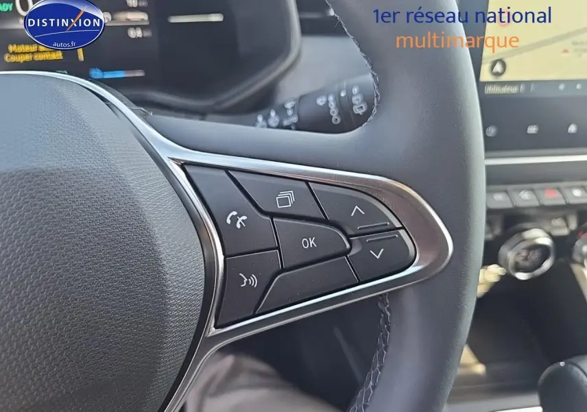 Gros plan sur les commandes multifonctions à droite du volant noir de la Renault Clio V 1.6 e-tech 145 techno.