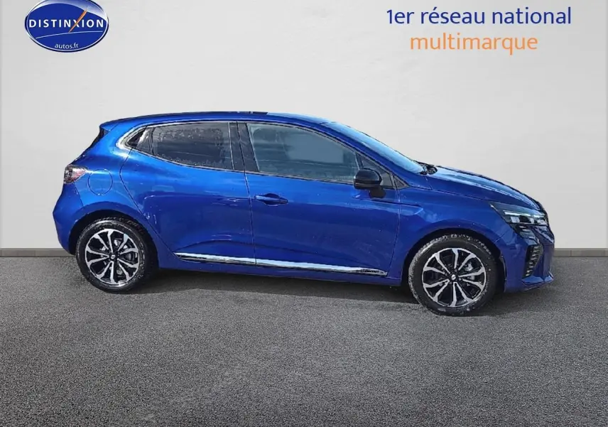Profil droit de la Renault Clio V bleu iron 2025 avec jantes alu et détails chromés sous un fond neutre.