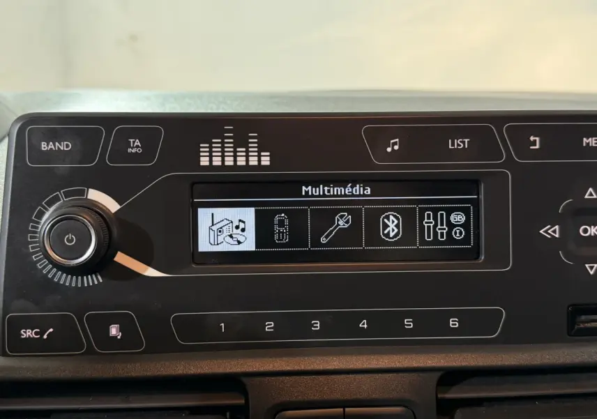 Tableau de bord noir du Peugeot Rifter 2019, affichage multimédia avec options Bluetooth et réglages audio visibles.