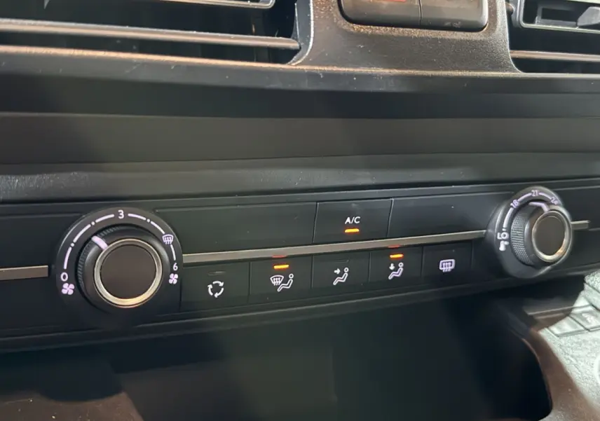 Gros plan sur la commande de climatisation du Peugeot Rifter blanc 2019, avec réglages de ventilation et température visibles.