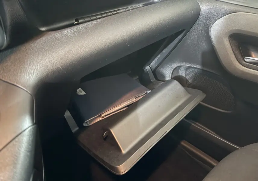 Vue intérieure du coffre à gants ouvert côté passager du Peugeot Rifter 2019, avec un carnet noir à l'intérieur.