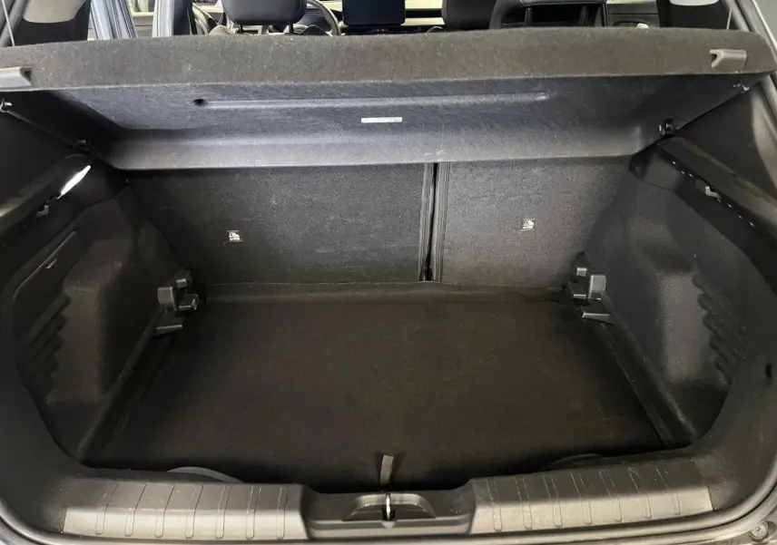 Coffre ouvert du Jeep Avenger gris 2024, vue arrière montrant l'espace de chargement et la banquette arrière.