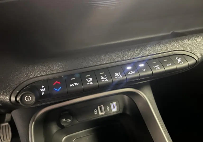 Gros plan sur la console centrale du Jeep Avenger 2024, boutons de climatisation et ports USB visibles.