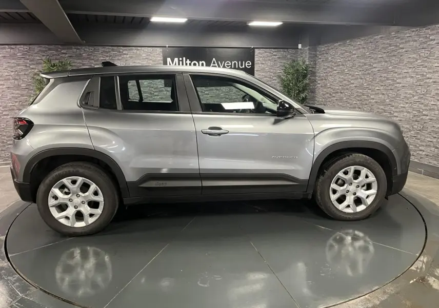 Vue de profil côté gauche du Jeep Avenger 2024 gris métallisé avec jantes alliage 17 pouces et coques de rétroviseurs noires.