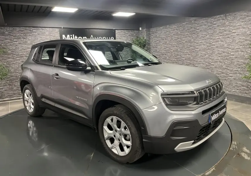 Jeep Avenger gris métallisé en vue 3/4 avant droit, avec calandre distinctive et jantes alliage 17 pouces.