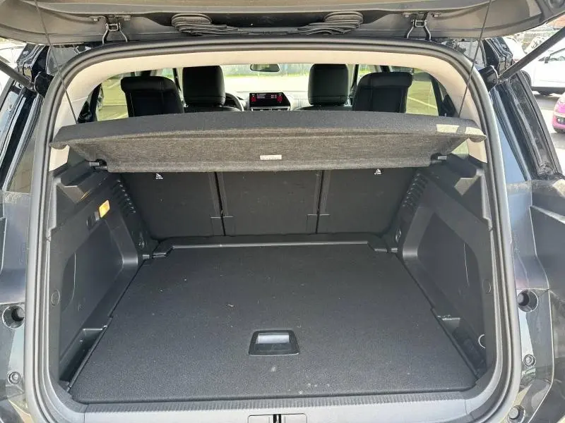 Coffre ouvert vu de l’arrière d’un Citroën C5 Aircross noir Perla Nera avec cache-bagages en place.