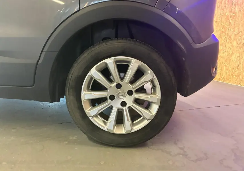 Gros plan sur la roue avant droite grise d’un Opel Crossland 1.2 Turbo 110 Elegance avec jante alliage argentée.