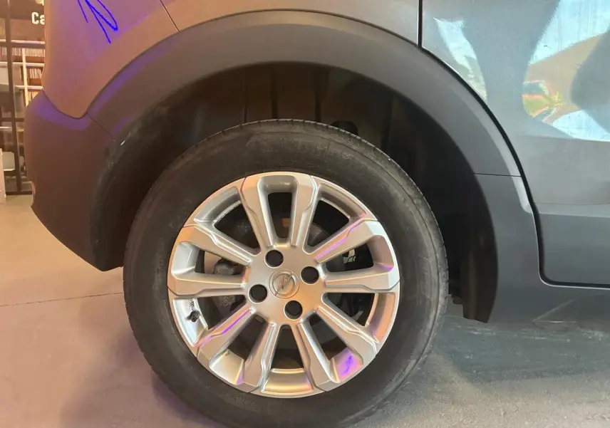Gros plan sur la roue arrière droite d’un Opel Crossland gris 2021 avec jante alliage et pneumatique Bridgestone.