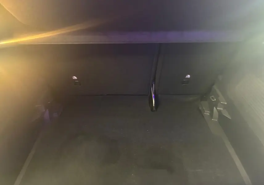 Coffre vide de l’Opel Crossland gris, vue intérieure en plongée montrant le tapis et les fixations arrière.