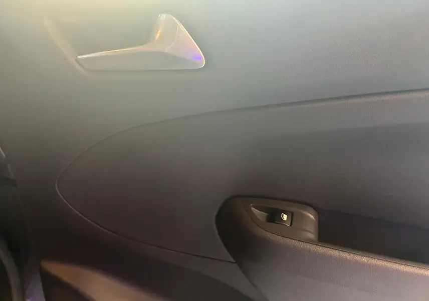 Intérieur côté gauche de la porte d’une Opel Crossland gris, avec poignée de porte et bouton de verrouillage.