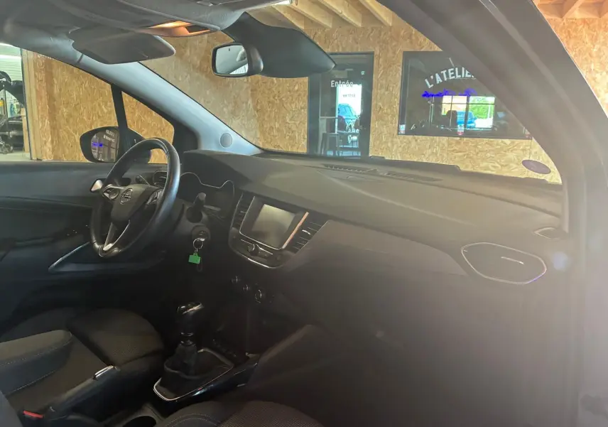 Intérieur de l’Opel Crossland 1.2 Turbo 110 Elegance 2021, vue côté conducteur, tableau de bord gris et volant noir.