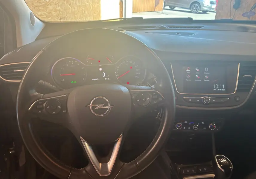 Vue intérieure centrée sur le volant Opel Crossland 1.2 Turbo 110, tableau de bord et écran tactile allumé.