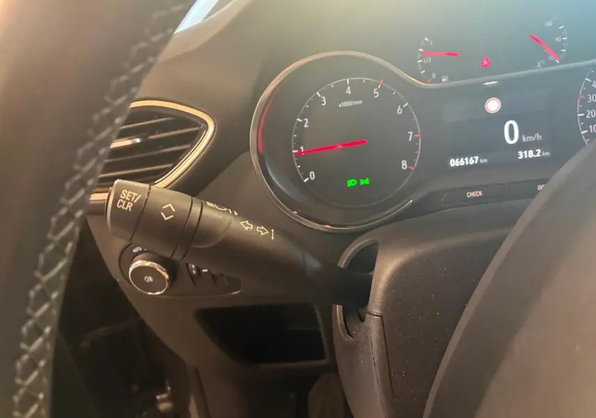 Vue rapprochée du tableau de bord de l’Opel Crossland gris, montrant le compteur et la commande de clignotant côté gauche.