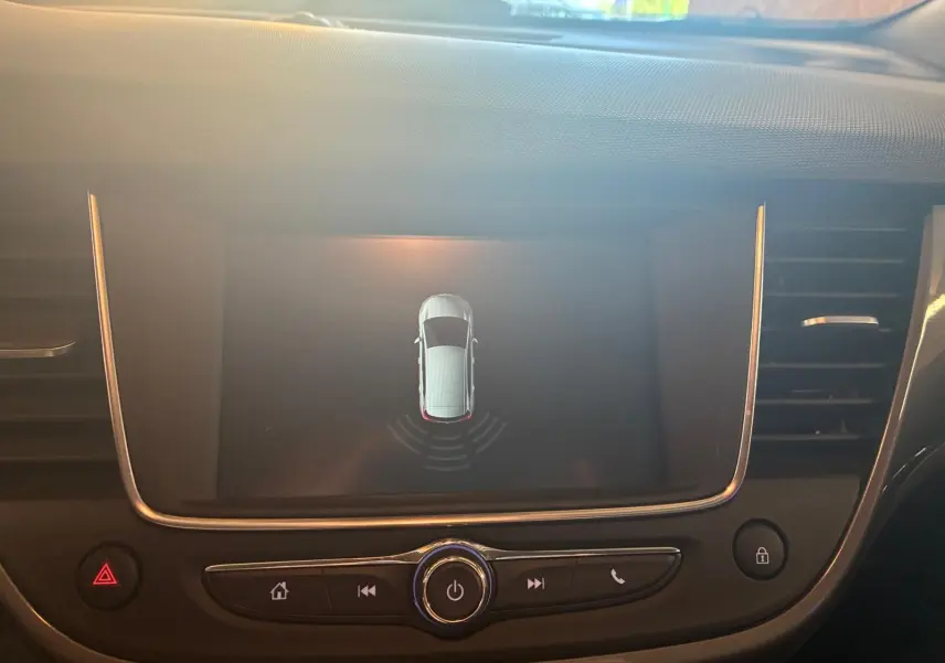 Vue rapprochée de l’écran central du tableau de bord d’une Opel Crossland gris, affichant le système d’aide au stationnement.