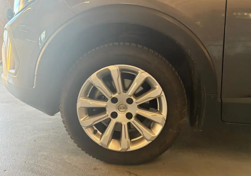 Gros plan sur la roue avant gauche grise d’un Opel Crossland 1.2 Turbo 110 Elegance de 2021.