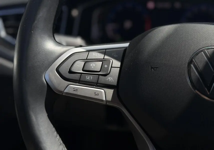 Gros plan sur les commandes gauche du volant cuir noir du Volkswagen Taigo TSI 116 DSG R-Line 2025.