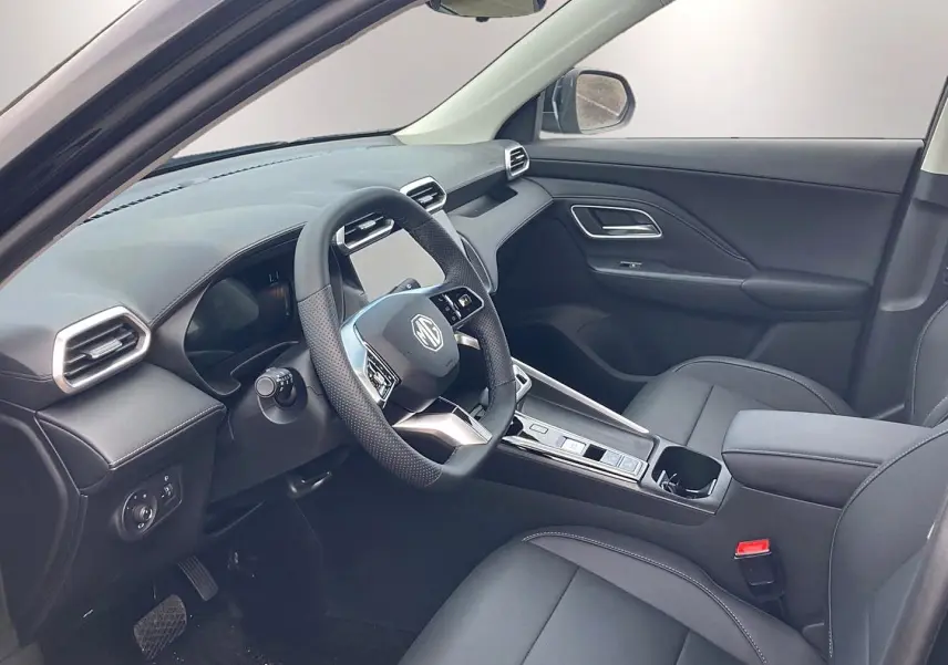 Intérieur noir du MG ZS 1.5 hybrid 197 luxury vu côté conducteur, avec volant multifonction et console centrale moderne.