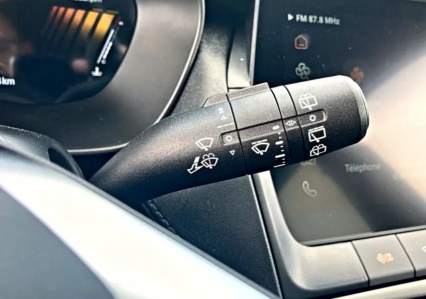 Gros plan sur la commande d’essuie-glace noire à gauche du volant dans l’habitacle du MG ZS 1.5 hybrid 197 luxury.
