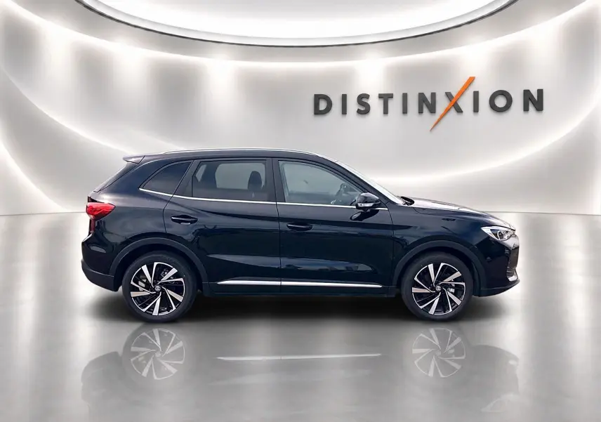 Vue de profil côté gauche du MG Motor ZS 1.5 hybrid noir avec jantes alliage et toit panoramique en studio lumineux.